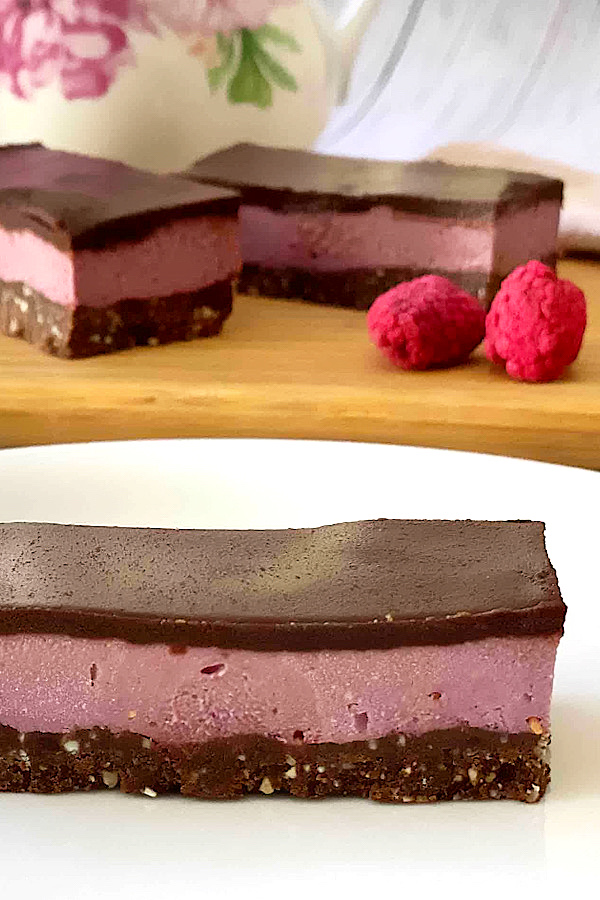 Close up of Raw Raspberry Chocolate Slice with 2 more in the background.