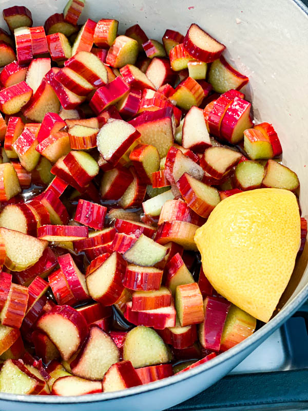 Chopped rhubarb in a pot with sugar, water, vanilla and half a lemon