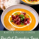2 bowls of Roasted Pumpkin Soup, one in front of the other with a few slices of sourdough bread in the background. The soup is topped with crispy bacon pieces, parsley and a swirl of cream.