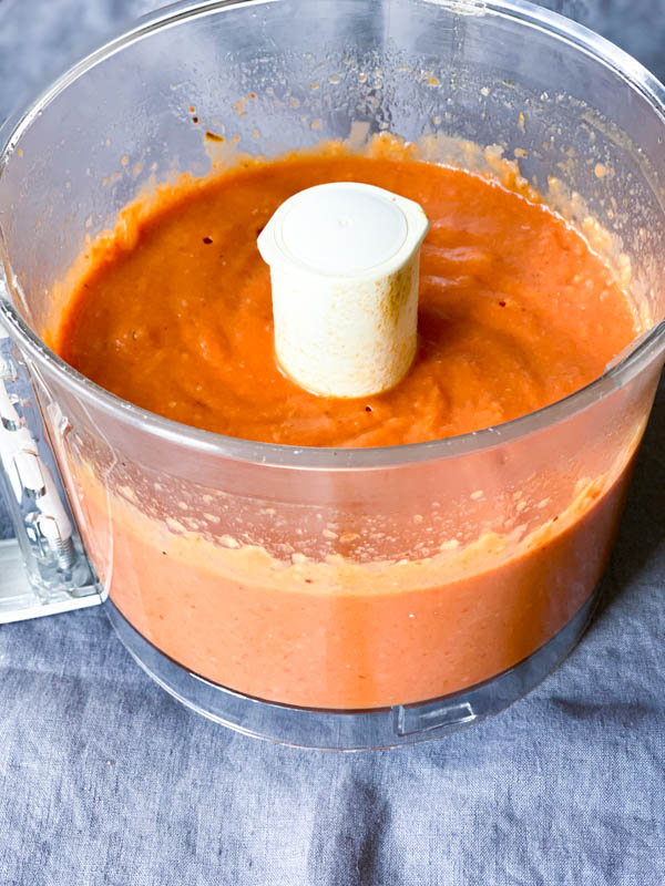 Blended and smooth Tomato Soup mix in processor bowl on the table.