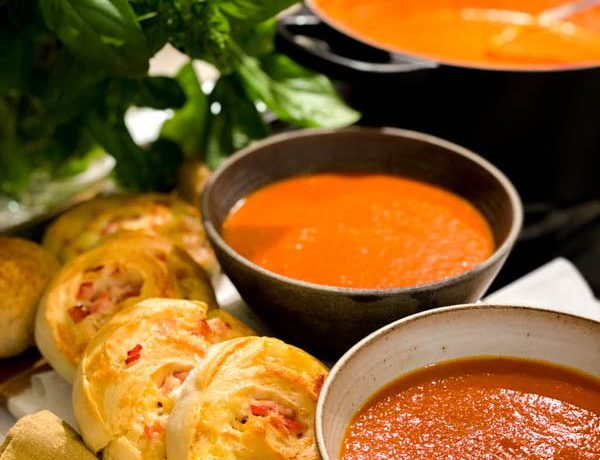 Close up of Roasted Tomato Soup in 2 bowls with Cheese and Bacon Scrolls.