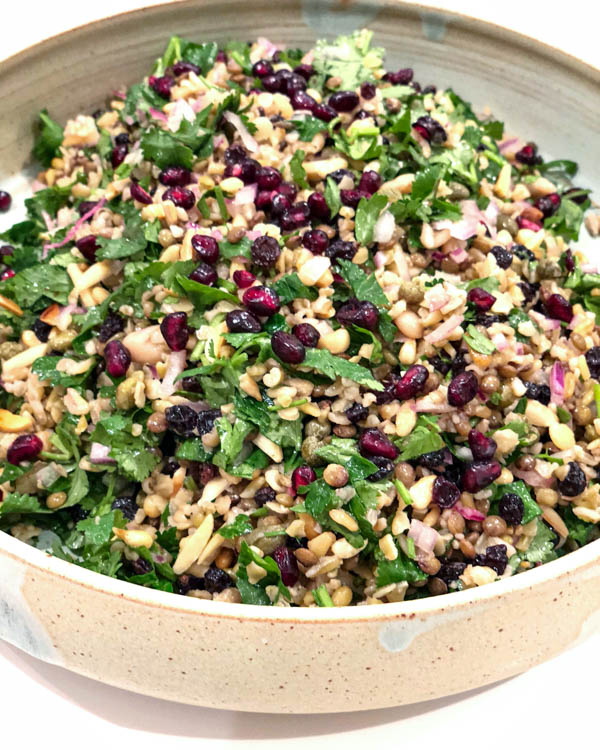 The Cypriot Grain Salad on a ceramic platter garnished with pomegranate seeds.