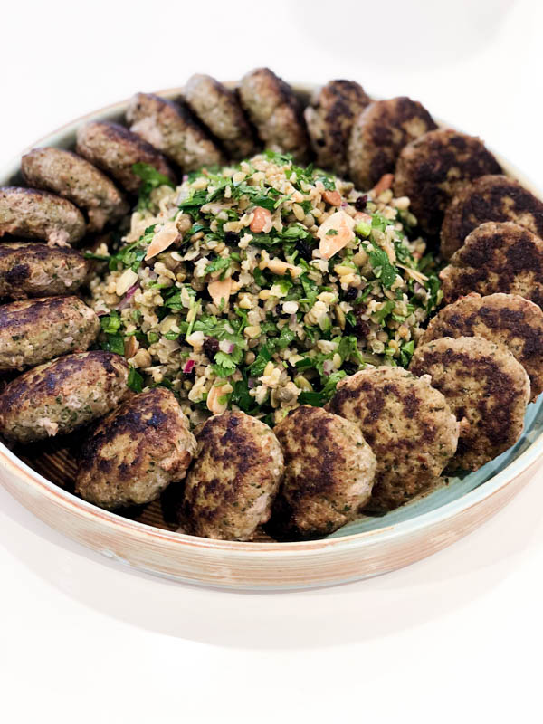 A round platter of Kofte patties with the Cypriot Grain Salad piled in the middle.