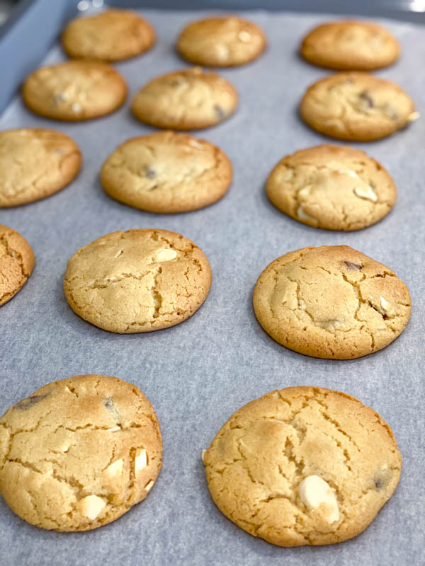 A baking tray of freshly baked Gingernut Biscuits in 3 rows.