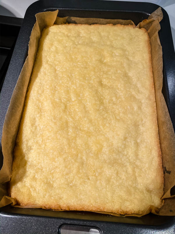 The cooked shortcrust base for the Gooey Yuzu Slice is out of the oven and cooling in the tin.