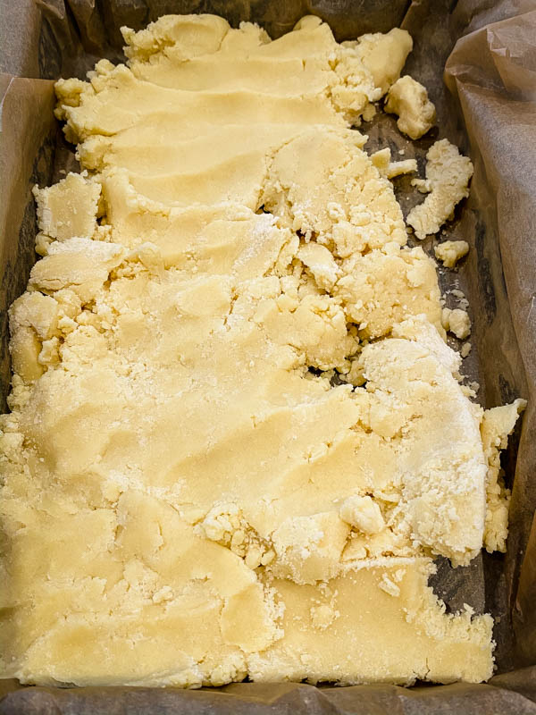 The shortcrust pastry base is in the slice tin and ready to be pressed down to form the first layer of the Gooey Yuzu Slice.