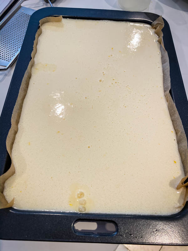 The yuzu curd layer is poured into the slice tin and about to go into the oven.