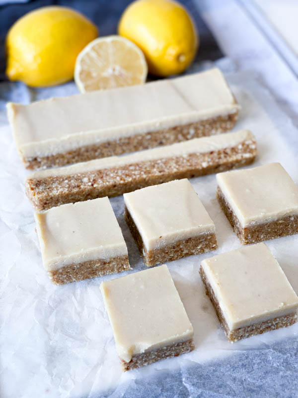 Side front view of Raw Lemon Slice on baking paper with lemons in the background.