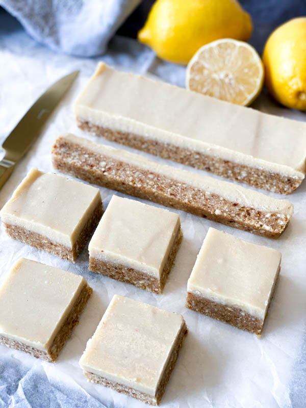 Close up of Raw Lemon Slice cut into squares with lemons in the background.