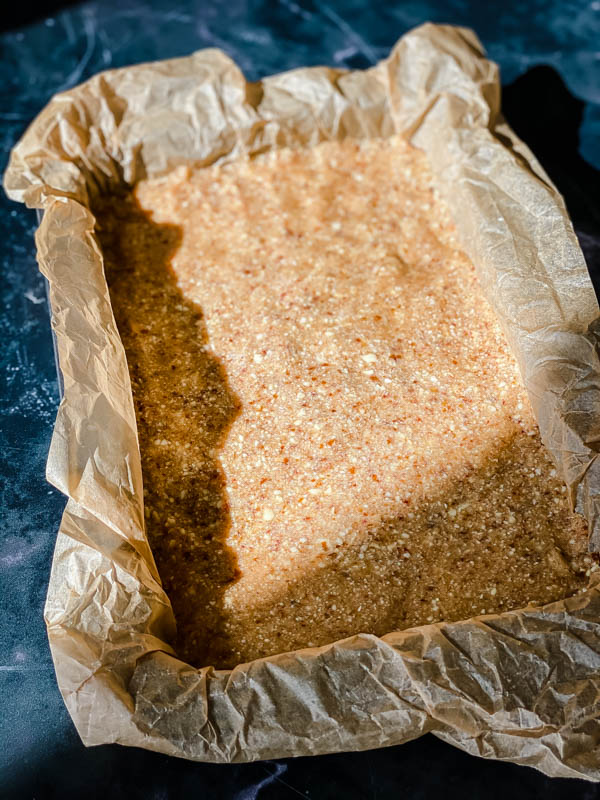 A baking tin showing the base of the Raw Lemon Slice pressed into the tin.