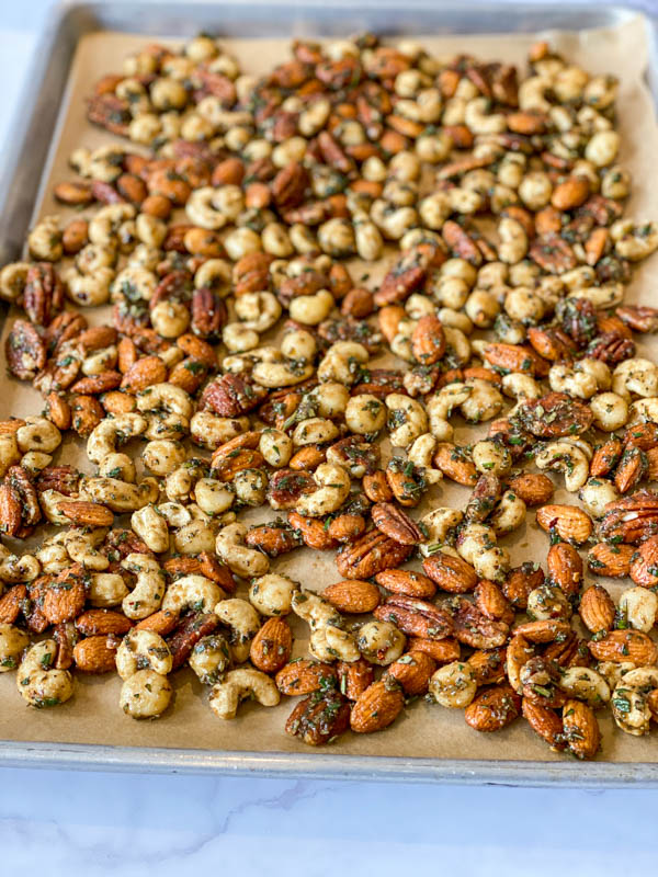 Sweet and Spicy Nuts spread out on a baking tray lined with brown baking paper, ready to be cooked.