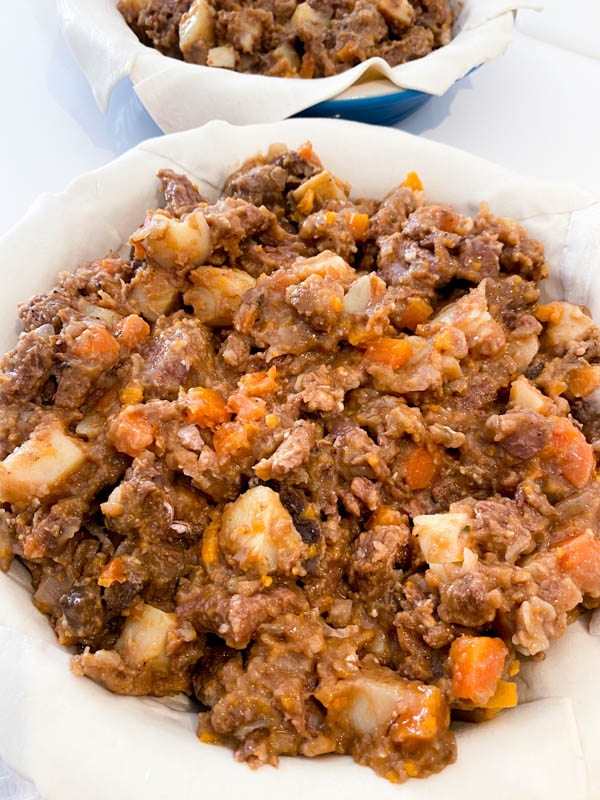 A pastry lined round pie dish filled with Beef and Vegetable filling.