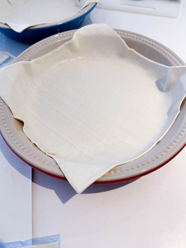 A round pie dish lined with one sheet of puff pastry.