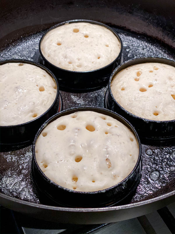The Sourdough Crumpets are cooking and the batter is starting to firm up on top with larger holes evident. They will be ready to be turned soon.