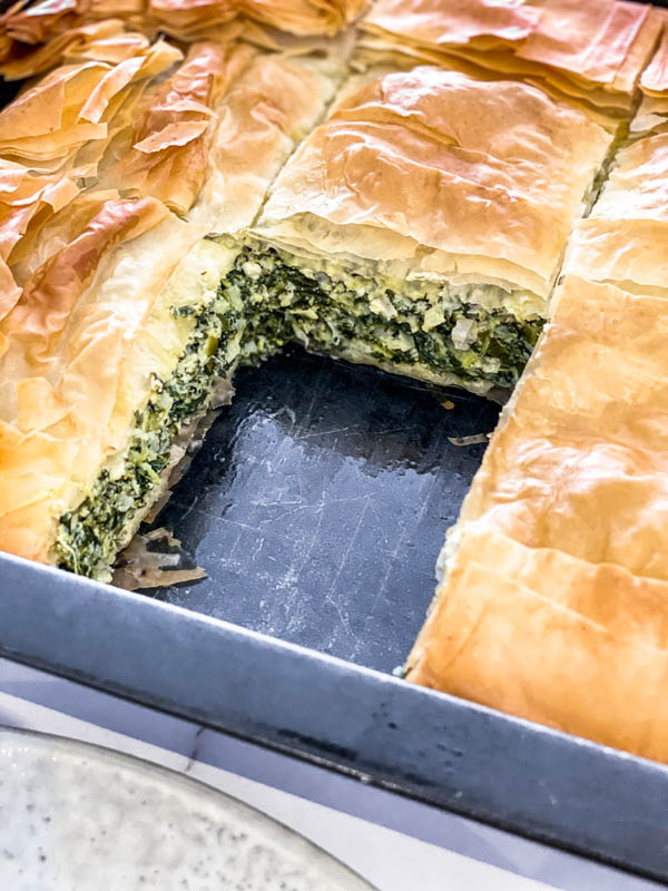 One serve of Spanakopita Pie is removed to show the inside of the pie.