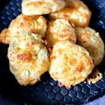 The Cheese Puffs are piled onto a black patterned plate.