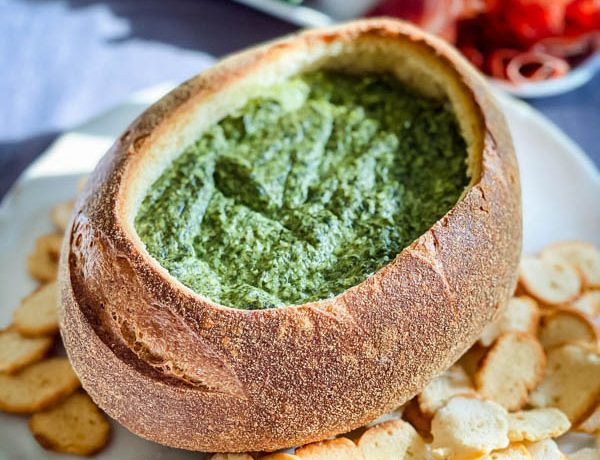 Close up of the Spinach Cob Loaf Dip with round bagel croutons surrounding it.