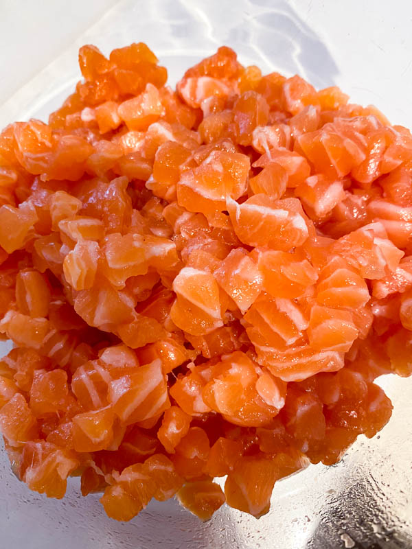A bowl of finely diced fresh salmon.