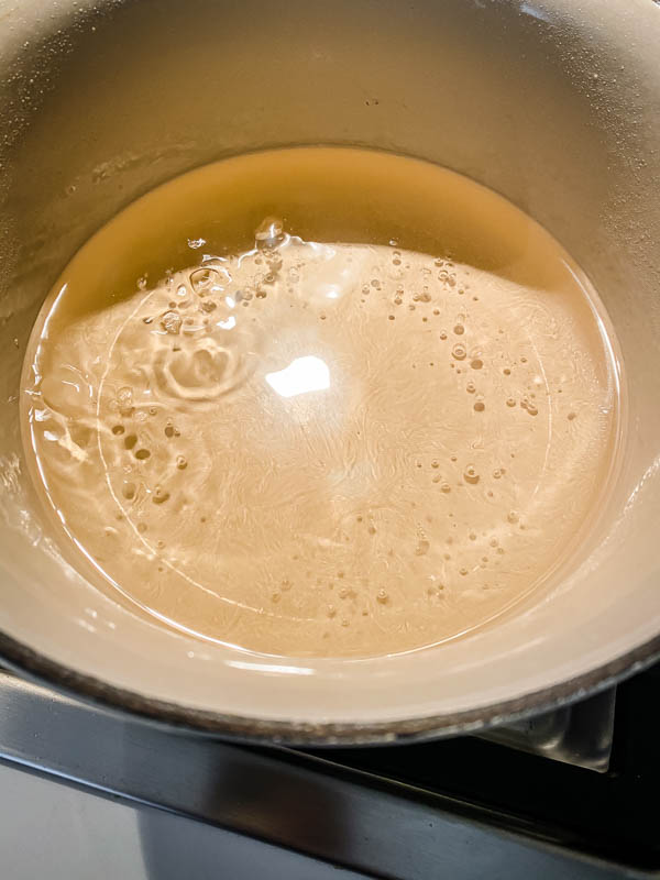 A small pot of sugar syrup boiling and reducing.