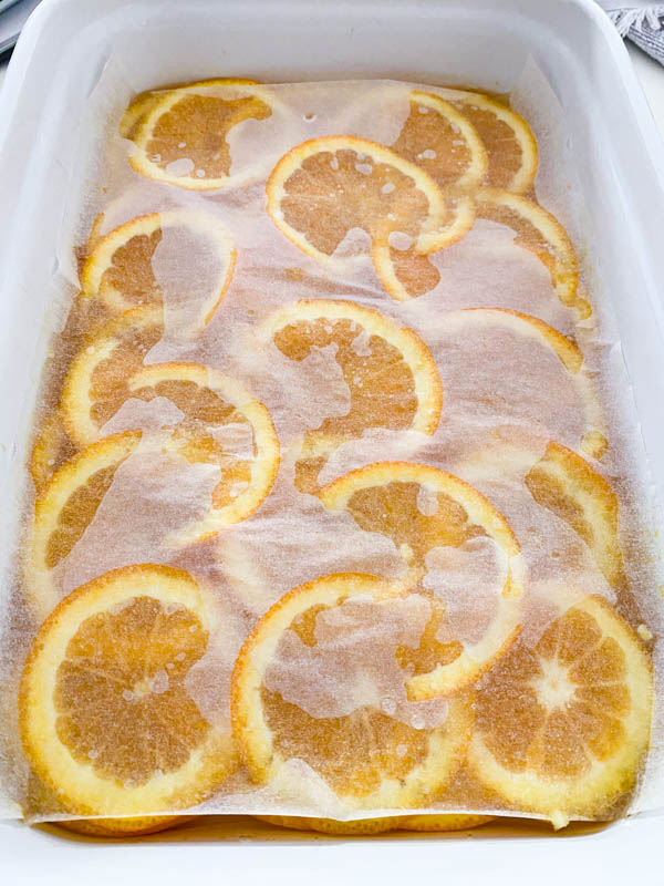 A piece of baking paper large enough to fit into the rectangle baking dish, is placed over the orange slices and syrup and pressed down lightly.