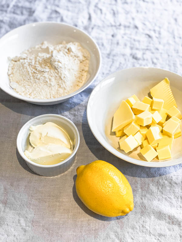 Bowls of ingredients (butter, flour, sour cream) and a lemon to make the Sour Cream Pastry for the galette.