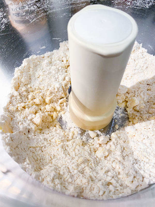 Showing the butter once it has been pulsed in the food processor. It shows that the butter is a little smaller than pea-sized balls.