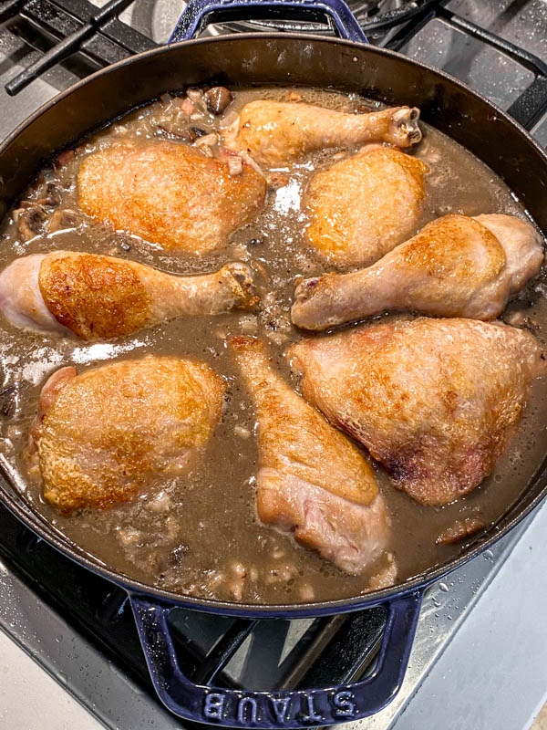 The browned and sealed chicken pieces (chicken thigh and drumsticks) are now back in the pan with the sauce. The chicken is skin-side up and the pan will now be put in the oven to finish cooking.