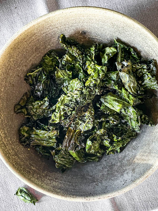 Looking down onto a bowl of crispy kale chips.