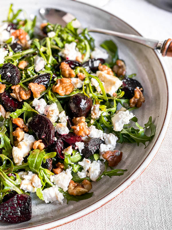 Close up of the salad with a salad server on the plate.