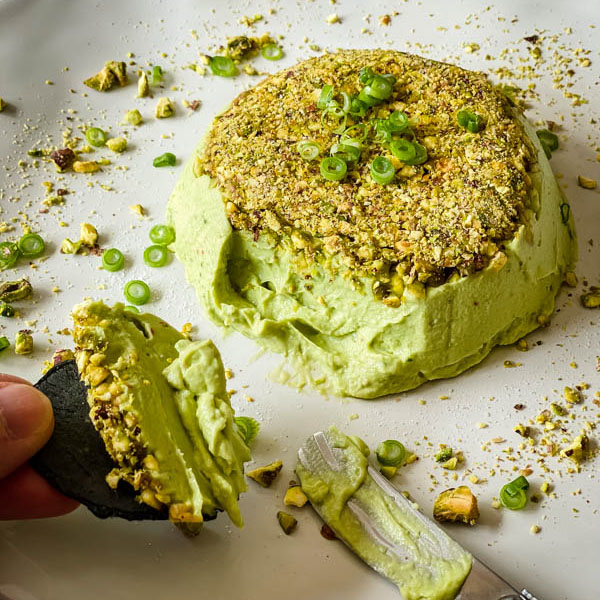 The pate is being eaten. A cracker is spread with pate and being held by the platter with a spreading knife beside it.