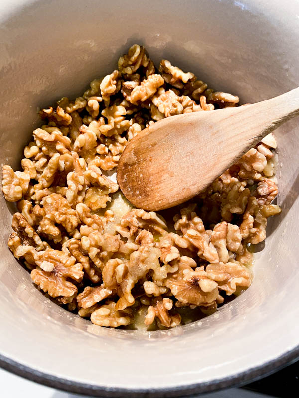 The raw walnuts have been added to a saucepan with the sugar mix.