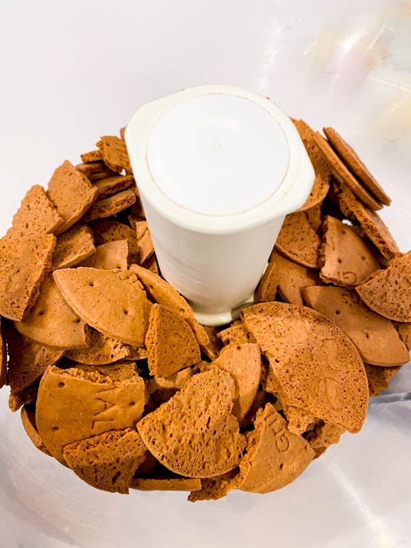 The broken malt biscuits are in the bowl of a food processor.