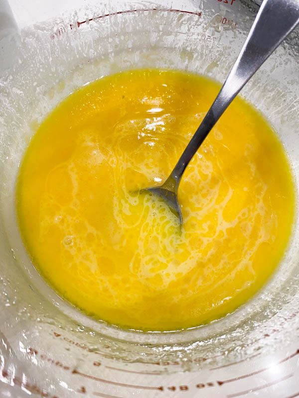The melted butter is added into jug with the sweetened condensed milk.