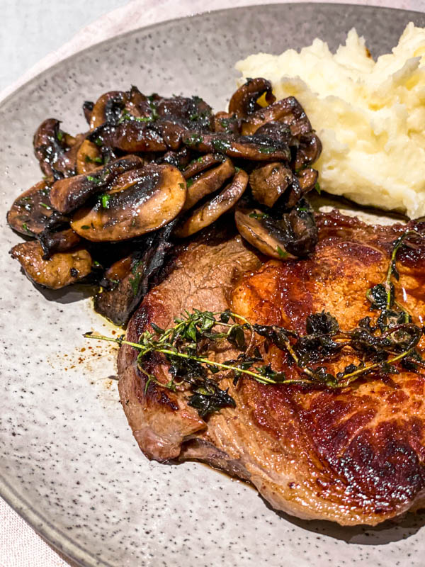 The roasted mushrooms are served with steak and mashed potato.