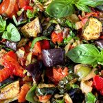 Close up of the Roasted Ratatouille Salad that is garnished with basil sprigs.