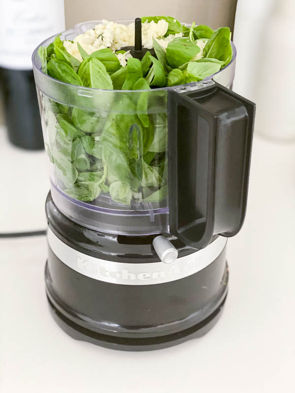 All the basil leaves are in a mini food processor along with the crushed garlic, ready to be blitzed together.