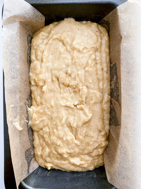 The batter is now in a loaf pan that is lined with baking paper.