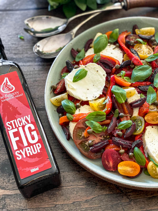 The Caprese Salad platter with a bottle of Sticky Fig Syrup beside it.