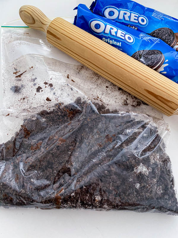 The Oreo biscuits have been crushed in a plastic bag using a rolling pin.