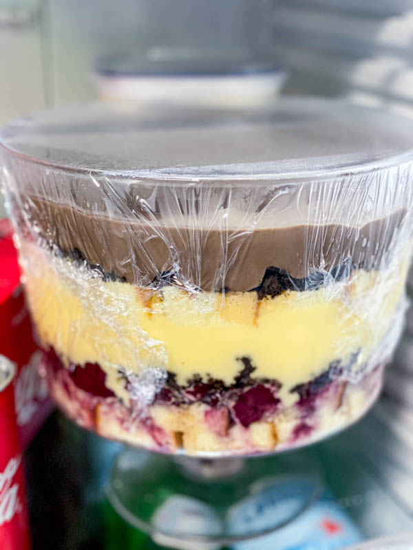 The assembled trifle is in the fridge and will then be topped with whipped cream and decorated.