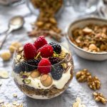 A close up of the parfait glass with granola, yoghurt and fresh berries.