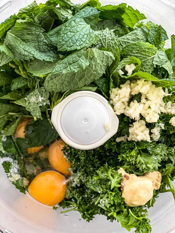 All the ingredients except the oil are placed into the bowl of a food processor.