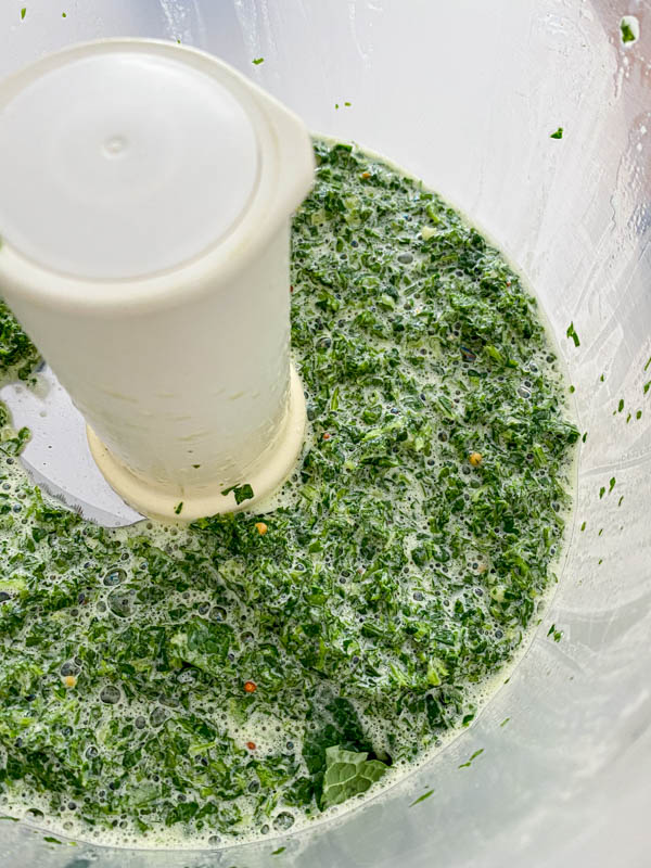 The ingredients for the Easy Mint Dressing are processed until finely chopped before the oil is drizzled in.