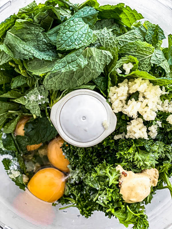 All the ingredients for the Mint Dressing are in the bowl of a food processor ready to be blended.