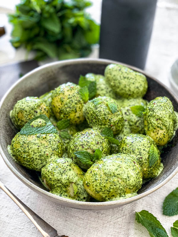 A close up of the New Potato Salad with Mint Dressing which has been decorated with a few fresh mint leaves.