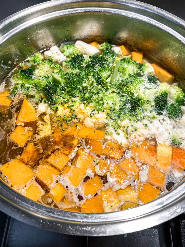 The rest of the vegetables are now added to the chicken stock in a pot.