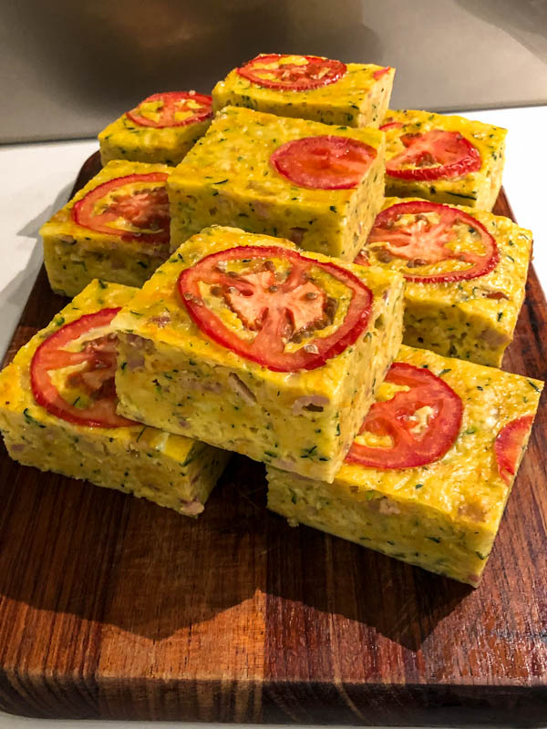 Squares of Zucchini Slice on a wooden board.