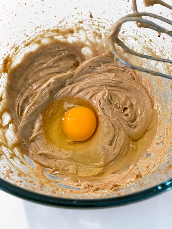 The second egg is added to the creamed butter and sugar mixture.