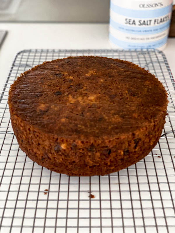 The cake is now cooked and resting upside down on a wire cake rack.