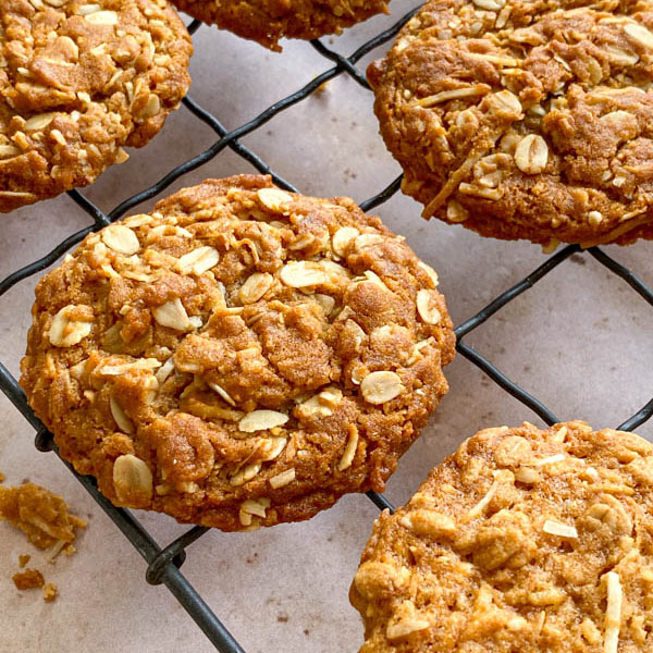 A side on view of one of the Chewy Anzac Biscuits resting on the wire cooling rack.